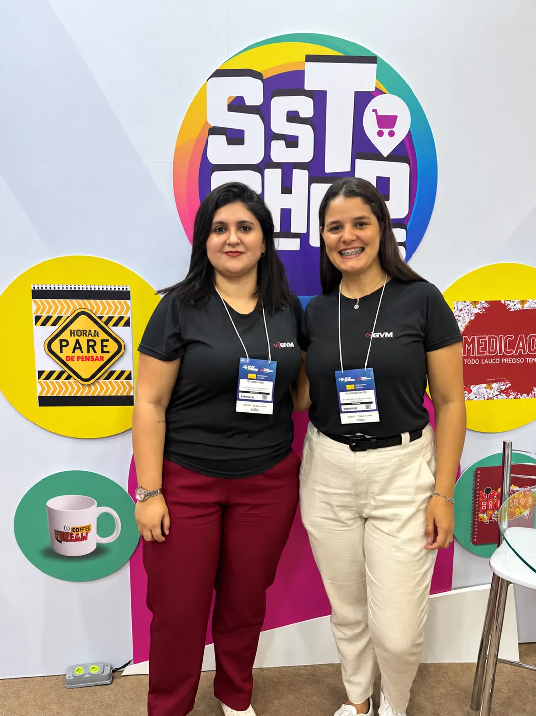 Duas integrantes da equipe em um evento de Segurança do Trabalho.