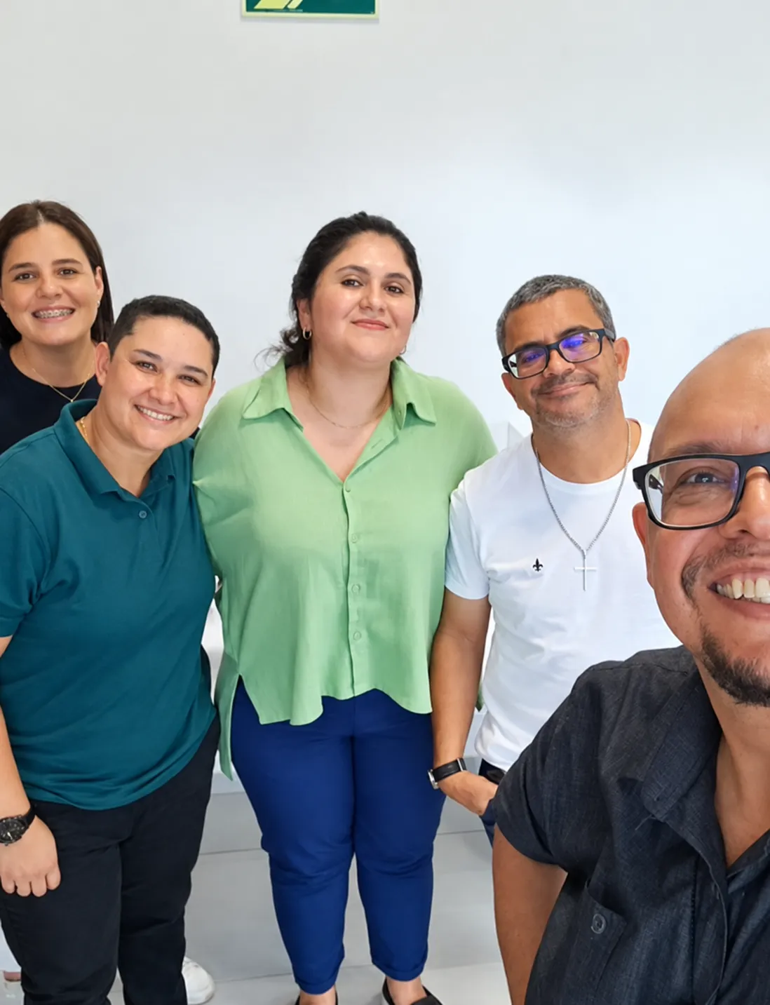 Cinco integrantes da equipe reunidos em ambiente interno.